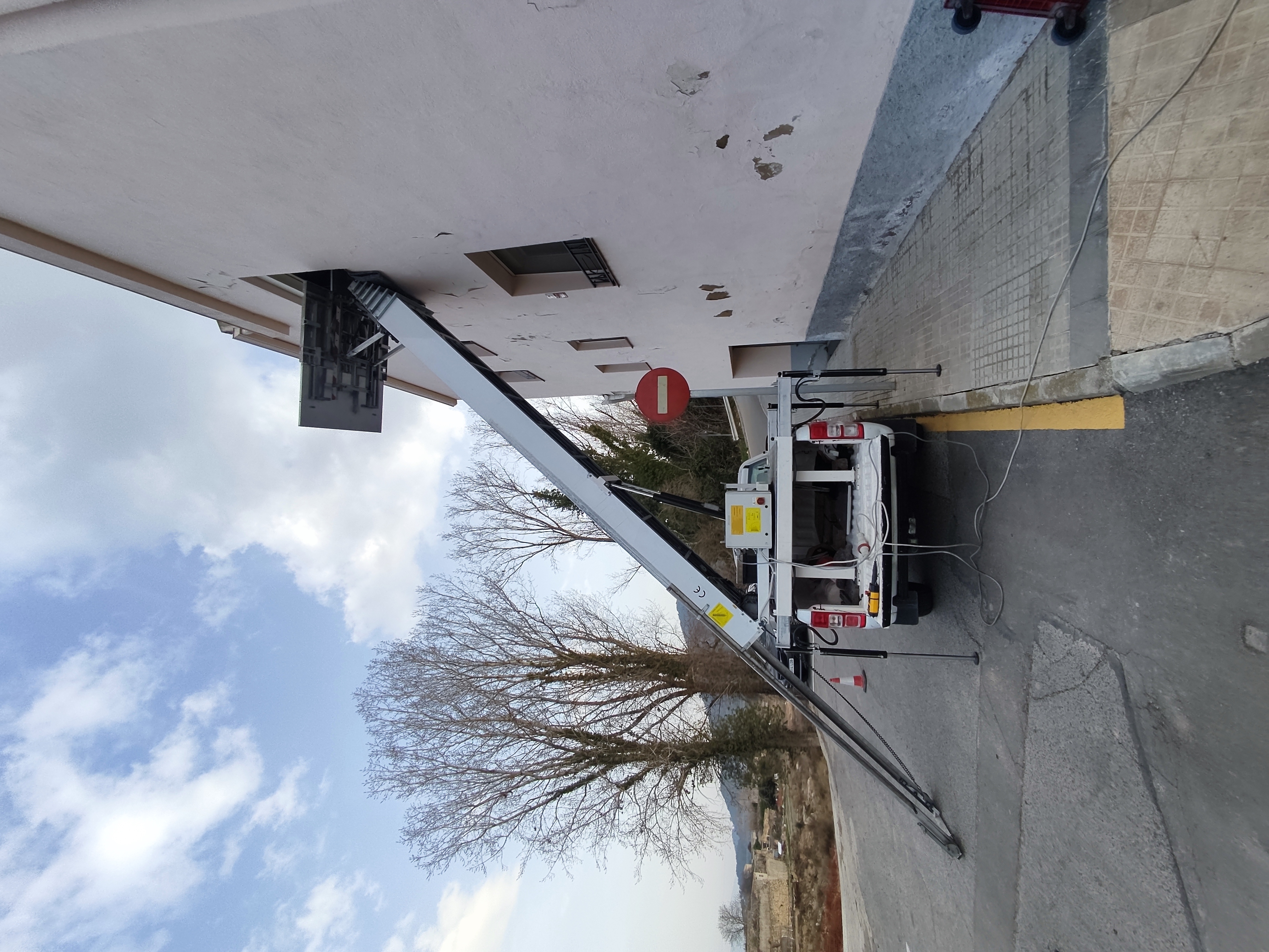 Camió grua de Mudances Sabaté davant edifici blanc amb senyal de stop