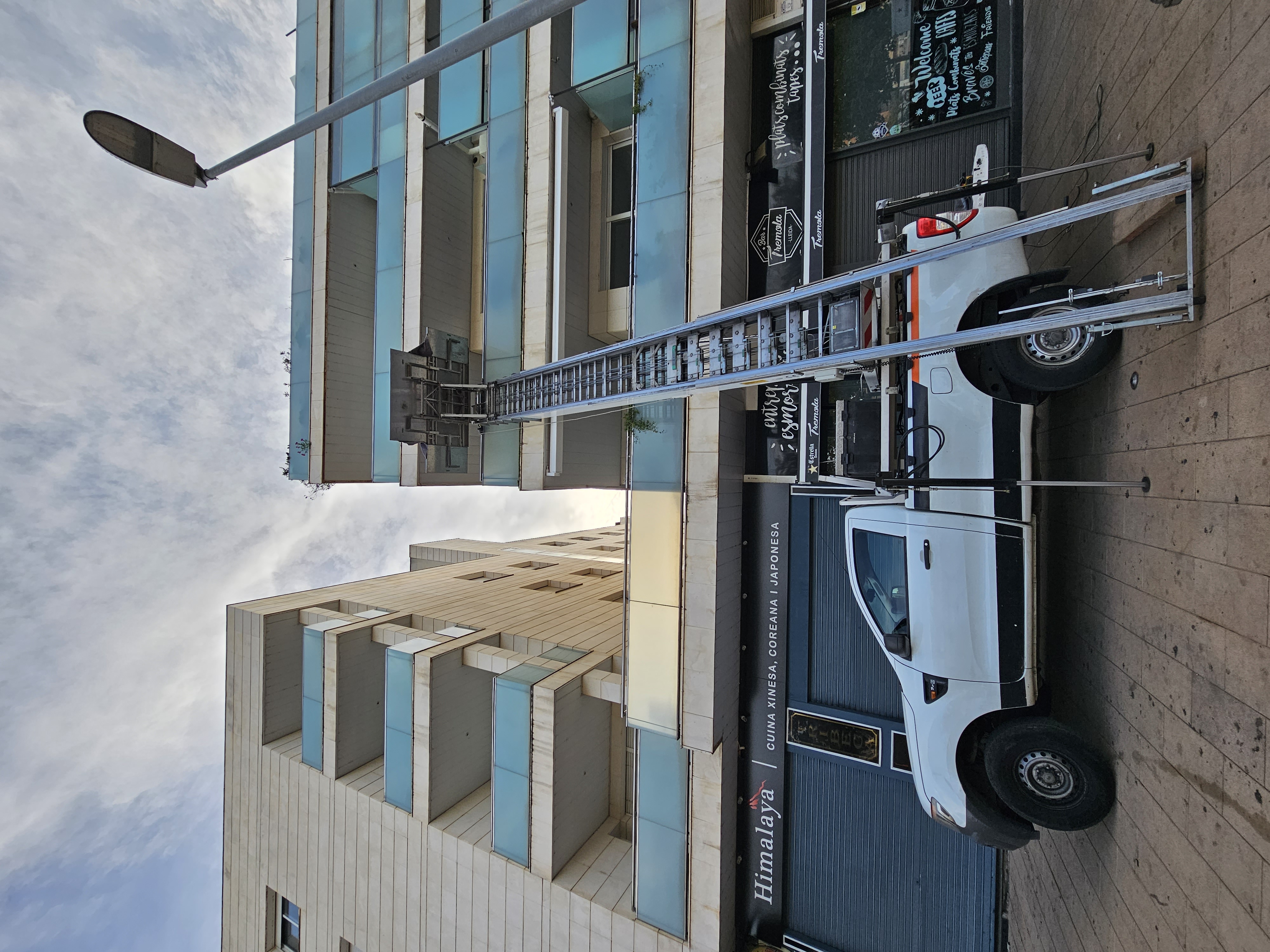 Camió grua de Mudances Sabaté davant edifici de vidre Himalaya